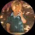 Tiny circular photo of a person amid warm lights