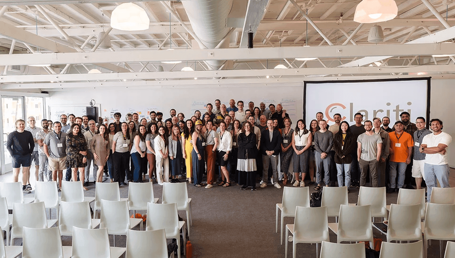Large group posing in a bright presentation room