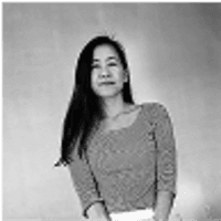 Small black-and-white photo of a person with long dark hair against a plain backdrop.