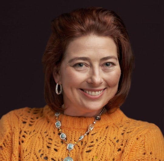 Smiling red-haired person in an orange sweater