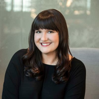 Smiling person with dark bangs wearing black